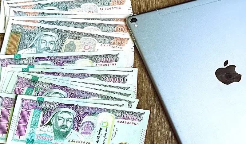 "Mongolian tugrugs next to an iPad, payment guide in Mongolia"