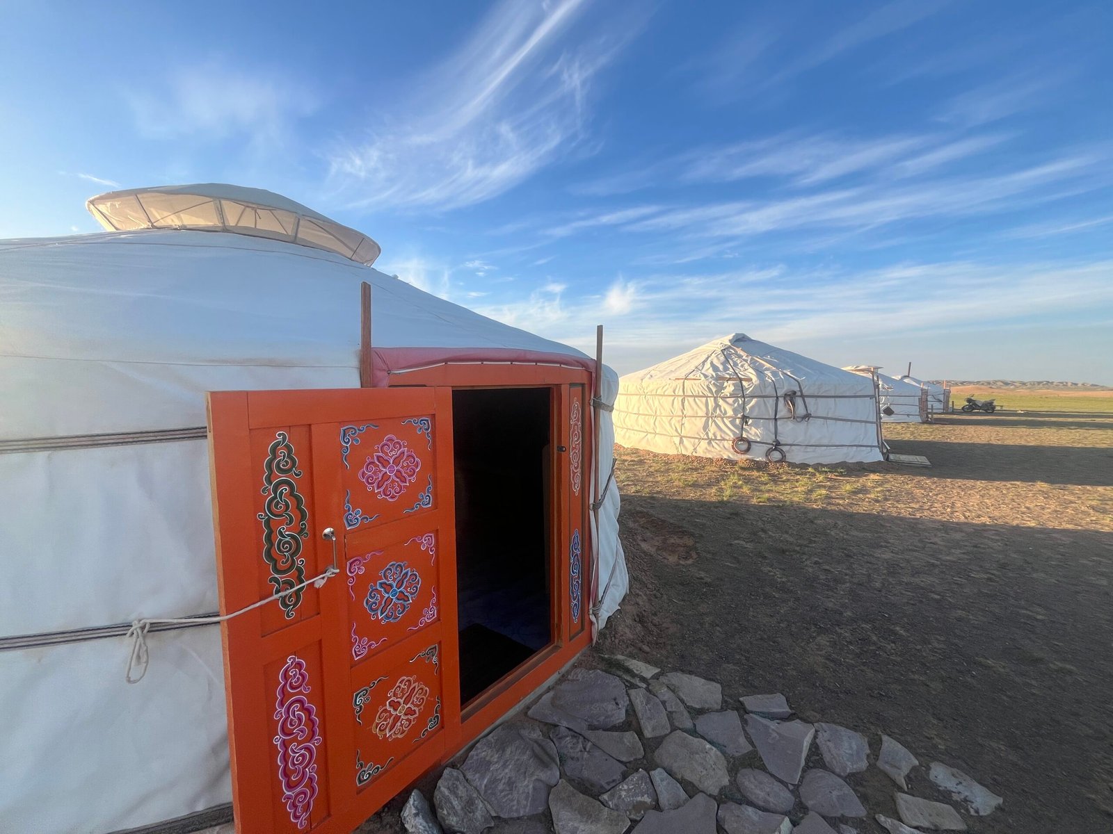 Traditional Mongolian ger with ornate painted orange door at a ger camp on the Gobi steppe