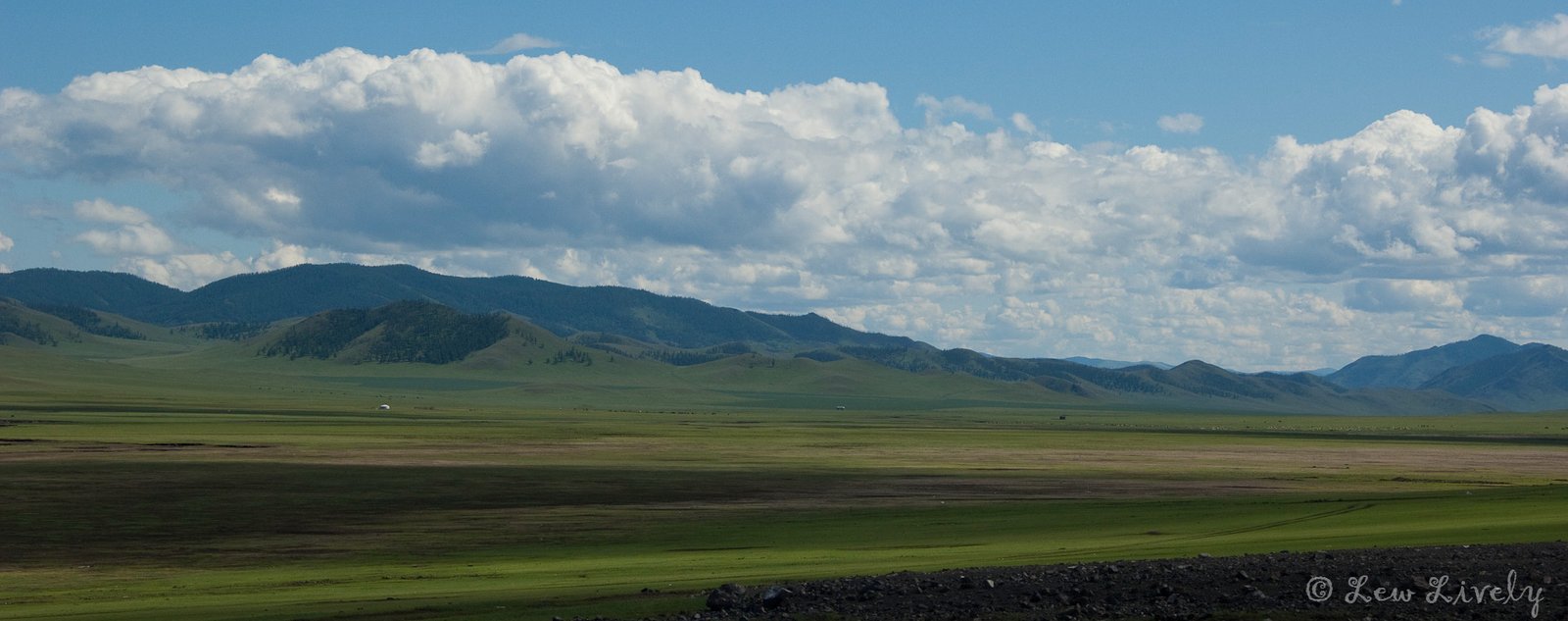 Vast Mongolian steppe with mountain panorama and dramatic clouds - Mongolia packing list guide