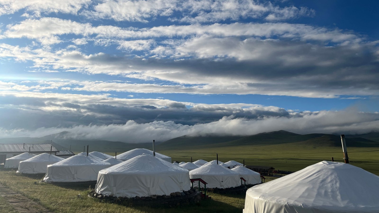 Traditional Mongolian ger camp on the steppe with dramatic cloudy sky