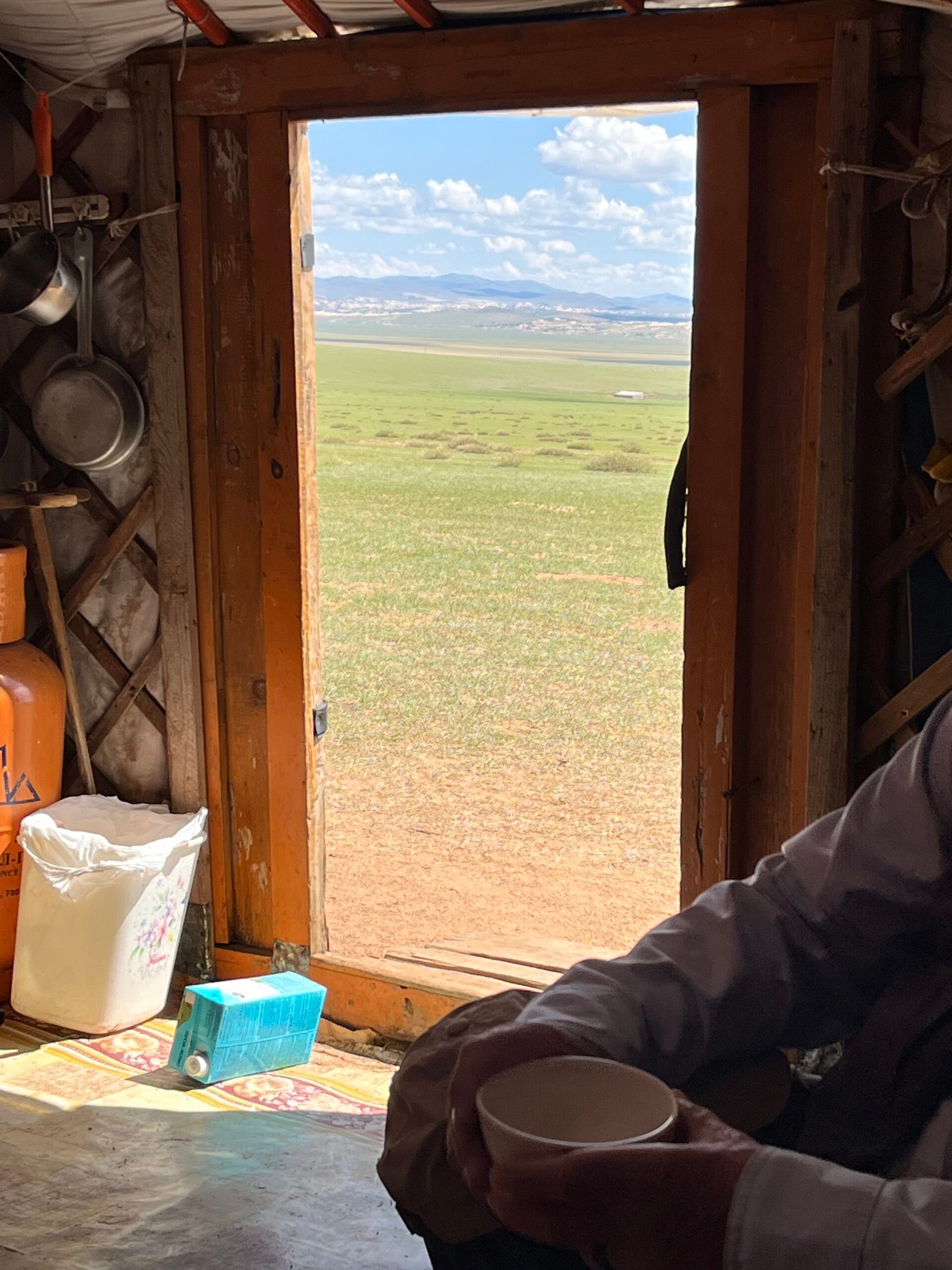 View through a Mongolian ger window looking out onto the vast open steppe landscape