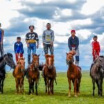 Mongolian children standing on horseback on open steppe — Mongolia Family Adventure Tour