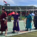 Traditional archers in deel costumes competing at Naadam Festival stadium Mongolia