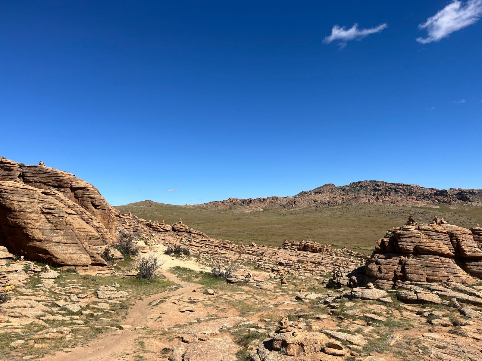 Baga Gazriin Chuluu granite rock formations rising from Mongolia's central steppe under a blue sky
