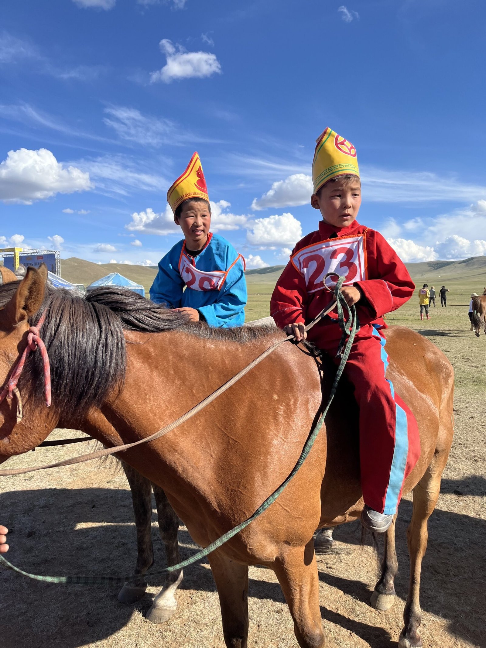 A young Naadam jockey in traditional costume on horseback